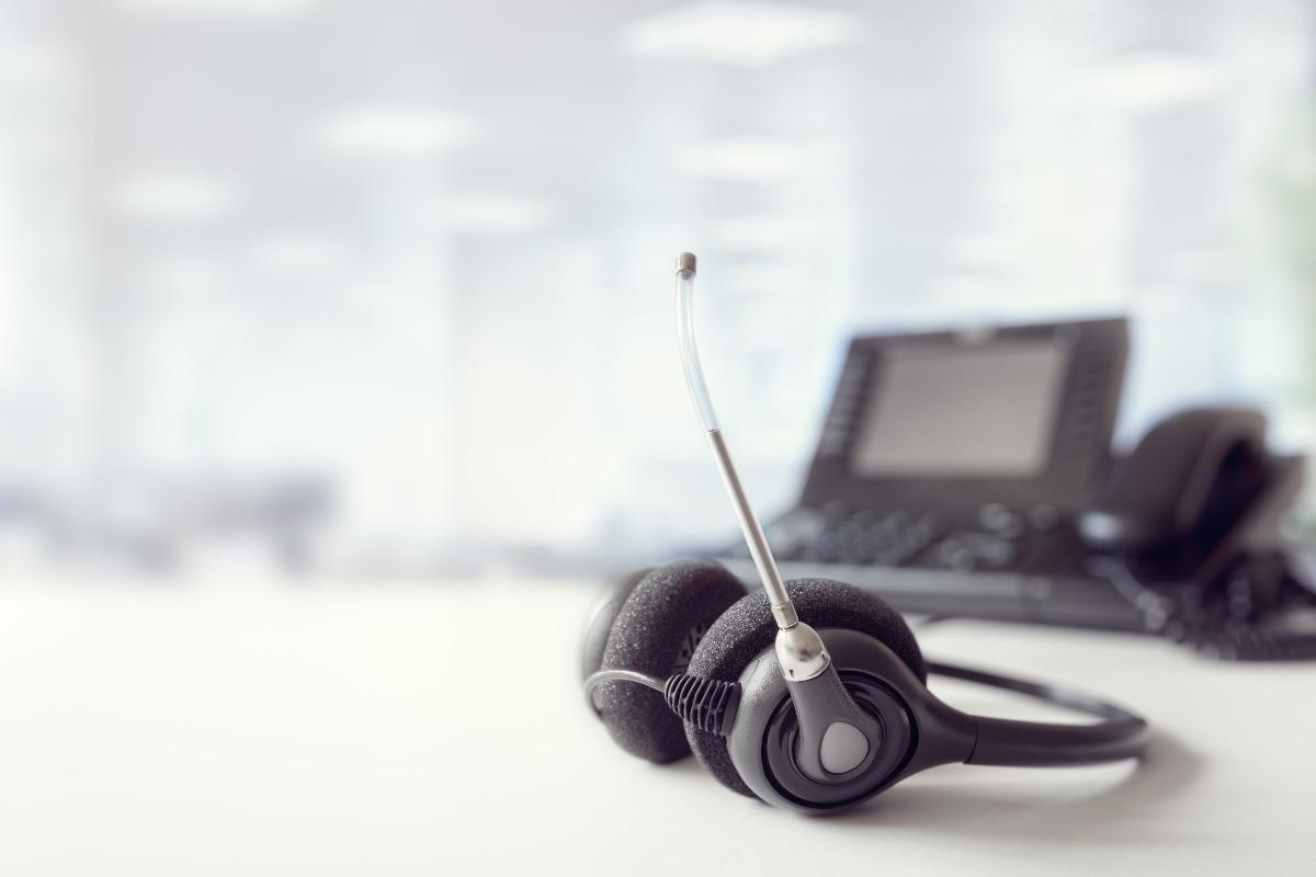 A business phone and a headset on a desk